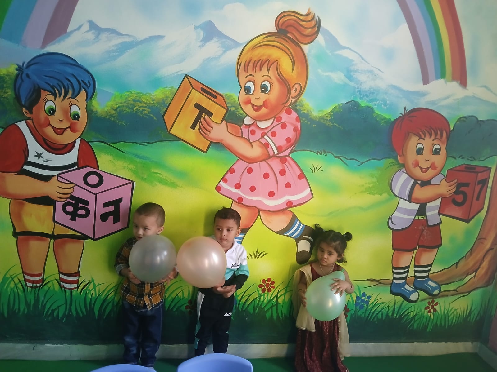 Children playing with balloons in front of a colorful alphabet mural at New Mother's Care Playway and Daycare